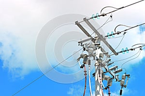 Electric pole in front of a clouded blue sky