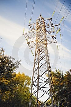 Electric pole with high-voltage wires against the blue sky