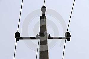 Electric pole made of concrete carrying 3 wires which gives current supply for homes
