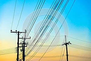 Electric pole with power lines against blue sky.