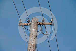 Electric pole power lines outgoing electric wires againts on cloud blue sky