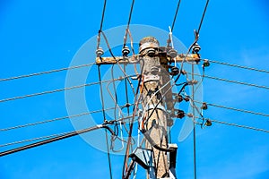 Electric pole power lines outgoing electric wires againts on cloud blue sky