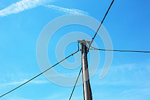 Electric pole power lines outgoing electric wires againts on cloud blue sky