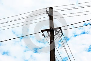 Electric pole power lines outgoing electric wires againts on cloud blue sky