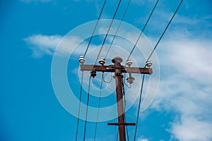 Electric pole power lines outgoing electric wires againts on cloud blue sky