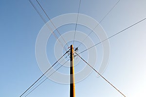 Electric pole with wires against a clear blue sky.