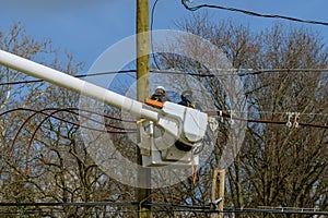 electric poles are being repaired by electricians installing wires to connect