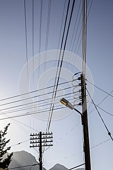 electric poles with many wires against the blue sky