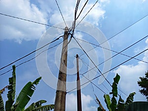 electric poles standing tall against the bright blue sky background