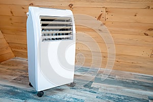 Electric portable heater in a wooden house in cold winter creates a comfortable climate and coziness but consumes a lot of