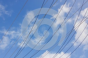 Electric power cables against blue cloudy sky with copy space photo
