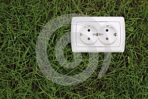 Electric power receptacle on grass background