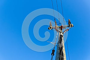 electric power sky lines and connections on a wooden post. wooden electricity post against blue sky. Electric power lines and