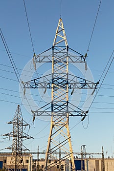 Electric powerline on electric substation and distribution power. High voltage power lines, pylons against blue sky