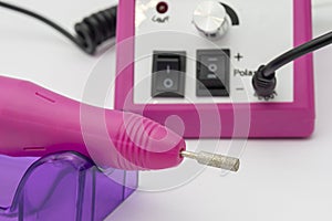 Electric professional pink manicure and pedicure machine, close-up. Nail care concept