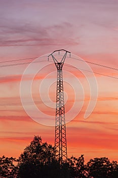 An electric pylon during a summer sunset