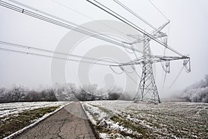 Electric pylon at winter with road in mountain