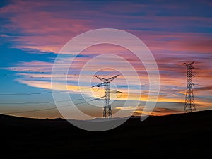 Electric pylons on a sunset with beautiful clouds photo