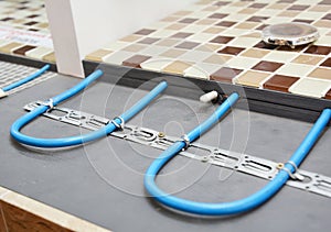 Electric Radiant Flooring Installation Concept. Installing radiant heat flooring or heated floor system in the bathroom during photo