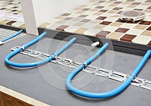 Electric Radiant Flooring Installation Concept. Installing radiant heat flooring or heated floor system in the bathroom during