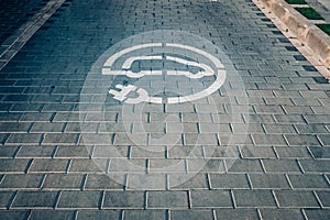 Electric recharging point for electric cars, EVs that pollute less, painted on the ground