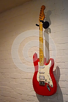 Electric red guitar with ragged strings.