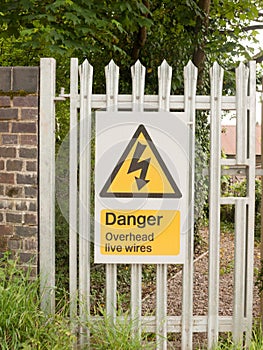 An electric safety sign outside on metal gate with electric bolt