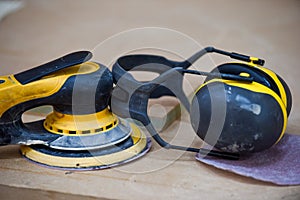 Electric sander and ear defenders for use in building and construction trade