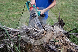 Electric saw in action cutting wood. Man cutting wood with saw, dust and movements. Close-up of woodcutter sawing chain saw in