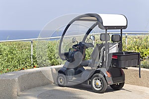 An electric scooter - car parked by the beach