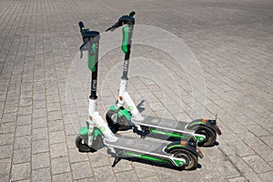 Electric scooter , escooter or e-scooter of the ride sharing company LIME on sidewalk