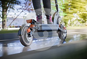 Electric scooter fast ride through the city - closeup to back wheel, motion blur effect