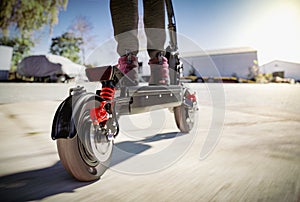 Electric scooter fast ride through the city - closeup to back wheel, motion blur effect