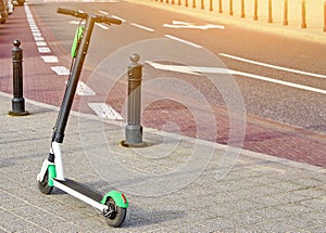 Electric scooter parked on the road. Modern eco electric city scooters for rent outdoors on the sidewalk. Alternative transporte. photo