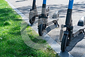 Electric scooter parked on sidewalk in city. Public mobile transport standing.