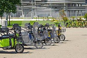 Electric scooters, three-seater mopeds at the parking lot for rental and movement around the city