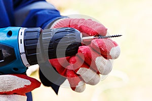 Electric screwdriver in the hands of a carpenter