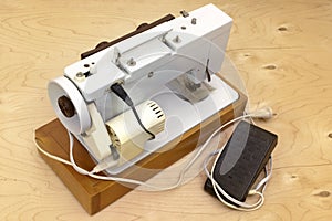 Electric sewing machine, on wooden platform