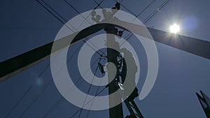 electric silhouette worker engineer working on electric pole standing on stairs