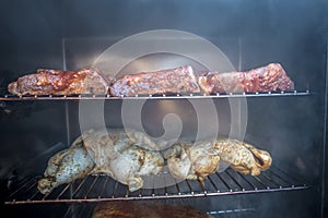 Electric smoker loaded with variety of meat