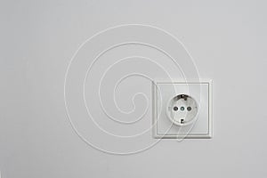 The electric socket on a white wall