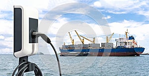 Electric station charger with plug and power cable supply and Large cargo ship for logistic import export goods anchor at sea in