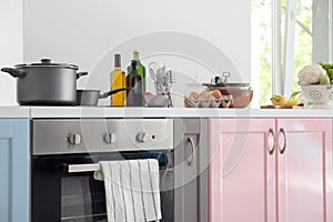 Electric stove with stewpan and products on table in modern kitchen