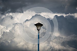 Electric street lamp against contrasty clouds