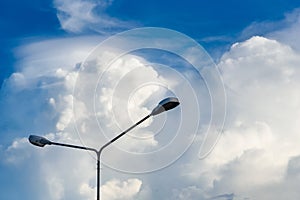 Electric street light pole on blue vivid sky in day light.