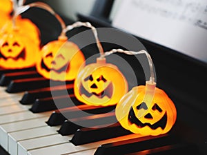 Electric string Halloween pumpkin lights on piano keyboard for Halloween party