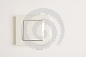 Electric switch with space for text on white wall.