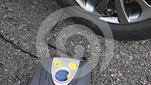 Electric tire inflator pumping up car tyre