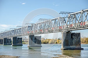 The electric train crosses the Ob river. Transsiberian railway. Autumn