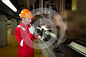 Electric train engineer use a walkie-talkie to inspect electric train machinery according to inspection round after the electric